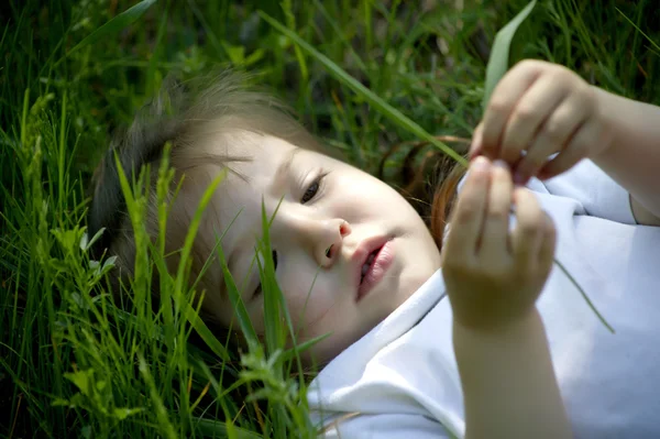 Niza niña se acuesta en la hierba verde —  Fotos de Stock