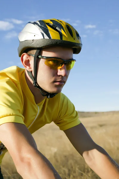 Joven ciclista en forma amarilla sobre la naturaleza Fotos De Stock