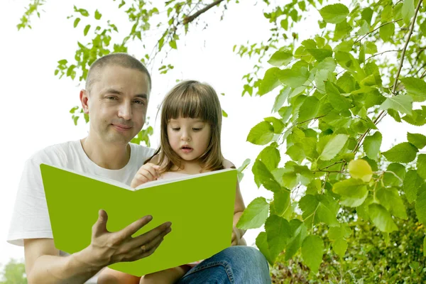 Apa és lánya, olvasson egy könyvet a természet Stock Fotó