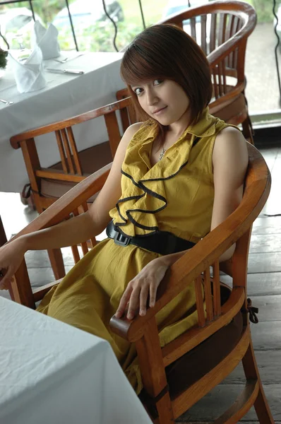 Νεαρή κοπέλα να καθίσουμε σε καρέκλα — Φωτογραφία Αρχείου