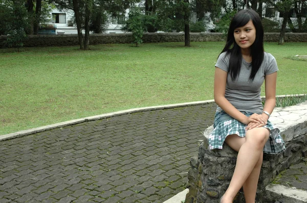 Jeune femme s'asseoir dans le parc — Photo