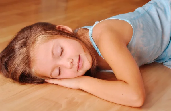 Девушка в синем спит, лежит на полу — стоковое фото