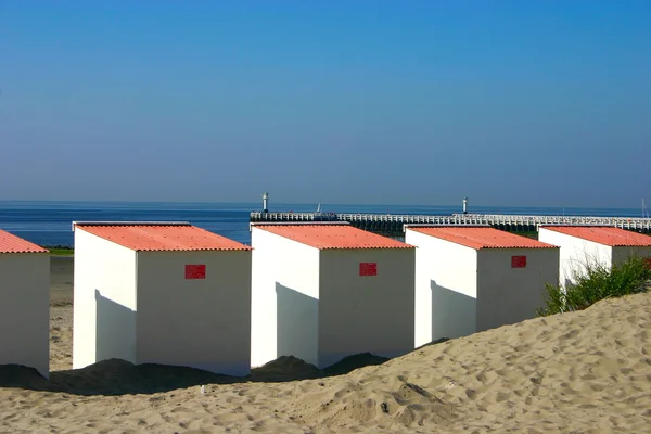Закрыть пляжные домики с пиром на заднем плане — стоковое фото
