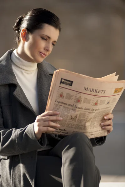 Reading newspaper outdoors — Stock Photo, Image