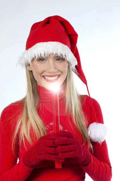 एक लाल मेणबत्ती धारण सांता च्या टोपी मध्ये सुंदर तरुण स्त्री — स्टॉक फोटो, इमेज
