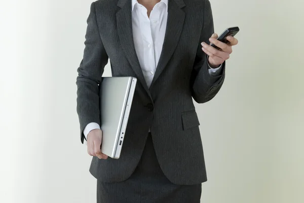 Zakenvrouw met laptop en mobiele telefoon — Stockfoto