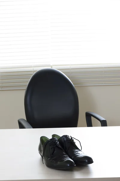 Männerschuhe auf dem Schreibtisch — Stockfoto