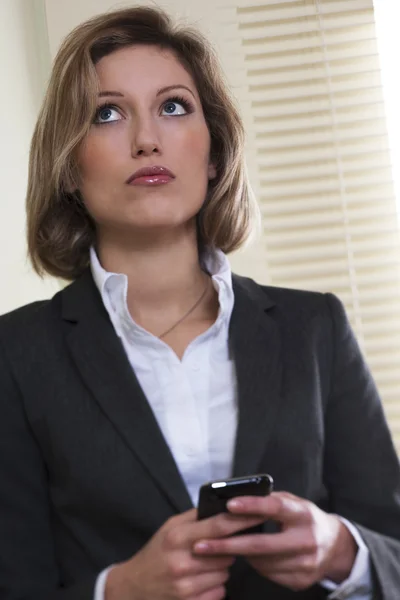 Femme d'affaires tenant un téléphone portable — Photo