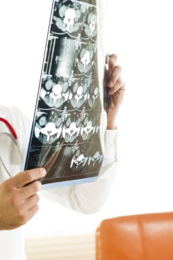 Male Doctor Examining a CAT scan clipart