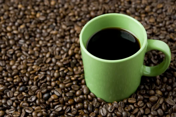 Чашка кофе на кофейных зеренах — стоковое фото