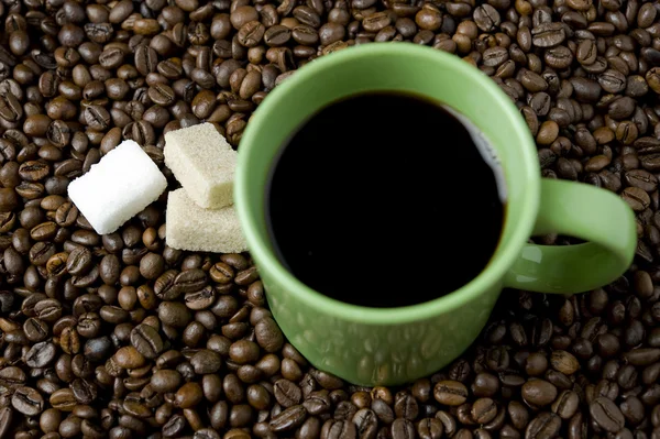 Kaffeetasse mit Zuckerwürfel und Kaffeebohnen — Stockfoto