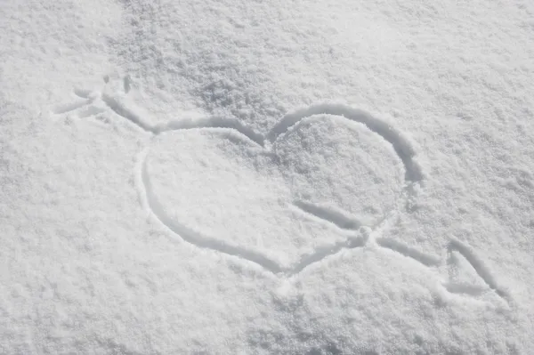Сердце со стрелой Купидона на снегу — стоковое фото