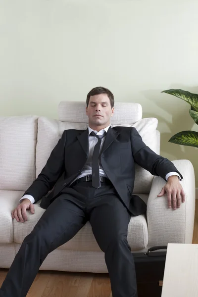 Втомлений бізнесмен на дивані — стокове фото
