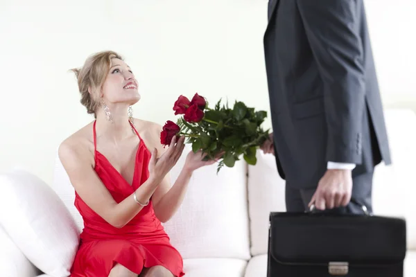 붉은 장미를 받는 붉은 회색빛 과놀란 여인 — 스톡 사진