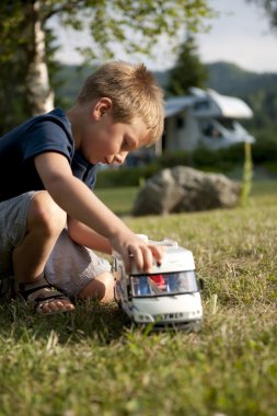 Little boy playing at camping site clipart