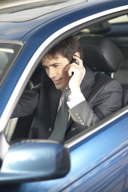 Businessman on the phone inside his car clipart