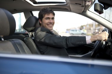 Smiling businessman driving car clipart