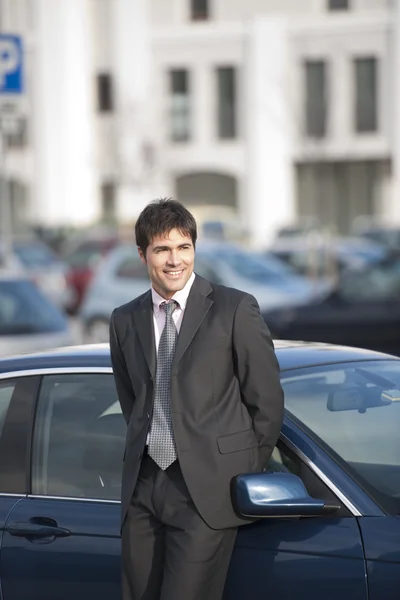 Lachende zakenman met een auto — Stockfoto