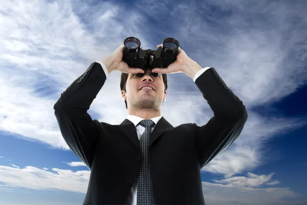 Businessman looking through a binoculars — Stock Photo, Image