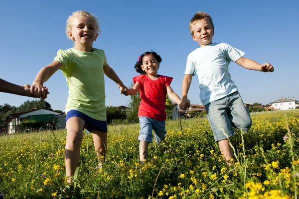 Трое детей бегут, держась за руки — стоковое фото