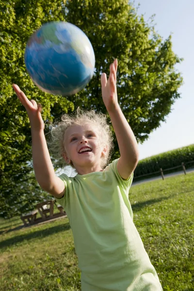 Gadis kecil menerima bola dunia — Stok Foto