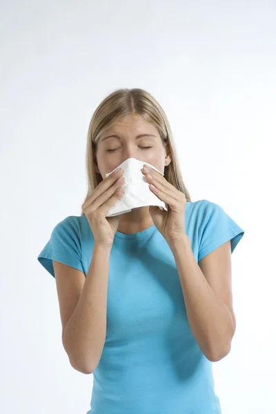 Young woman blowing her nose with kleenex — Stok fotoğraf