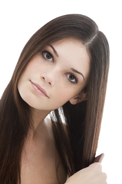 Mladá žena česání její vlasy — Stock fotografie