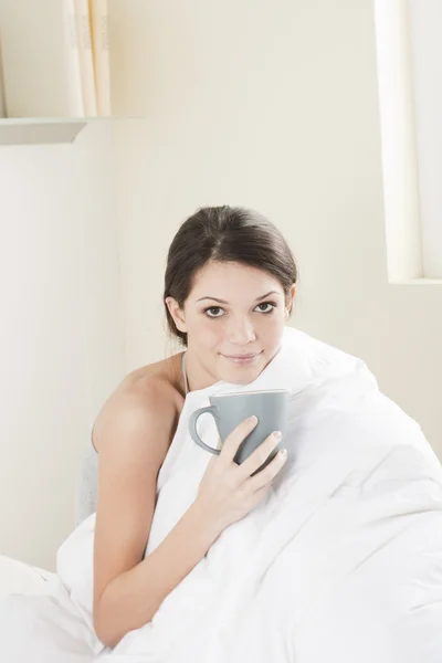 Młoda kobieta o śniadanie w łóżku — Zdjęcie stockowe