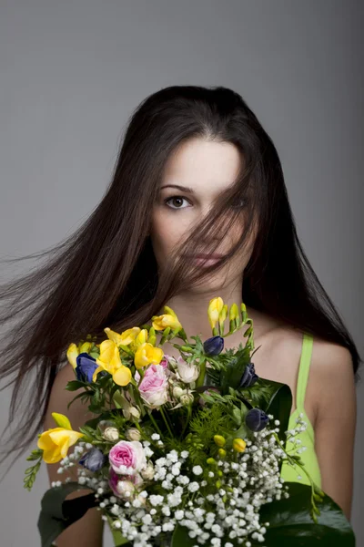 Schönheit mit einem Strauß Blumen — Stockfoto