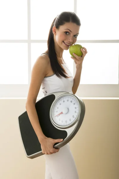 Mulher jovem segurando balança de peso — Fotografia de Stock