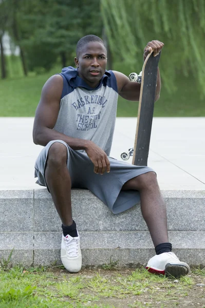 スケートボードを持つ若い男 — ストック写真