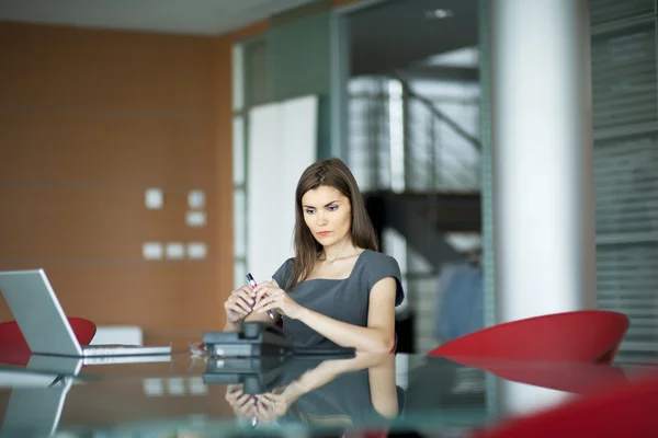 Pensive young woman at work — Stock Photo, Image