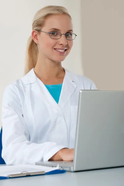 Mooie vrouwelijke arts werken op haar laptop — Stockfoto