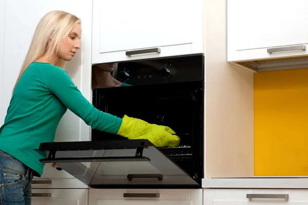 Young woman cooking with oven — Stock Photo, Image