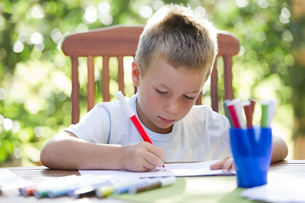Little boy coloring outside — Stok fotoğraf
