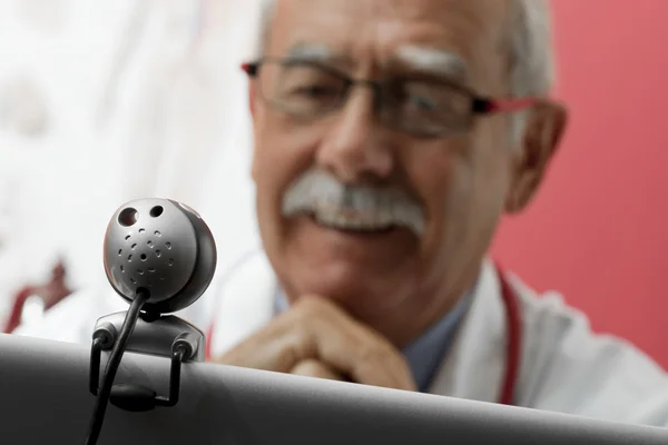 Усміхнений лікар використовує веб-камеру — стокове фото