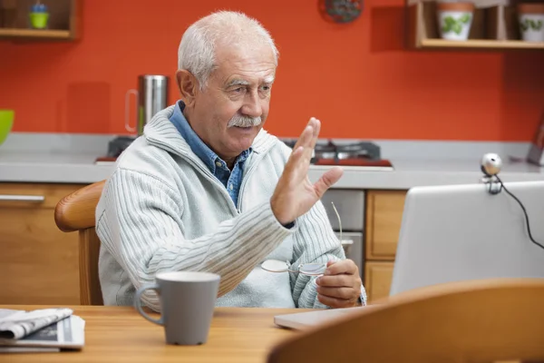 Starší muž mluví prostřednictvím webové kamery — Stock fotografie