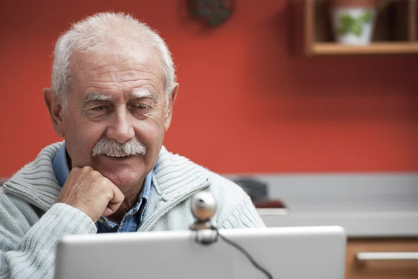 Senior man speaking through webcam — Stock Photo, Image