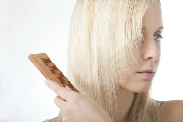 Блондинка расчесывает волосы — стоковое фото