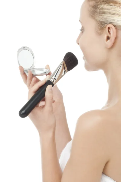 Kvinna med puderborste och spegel — Stockfoto