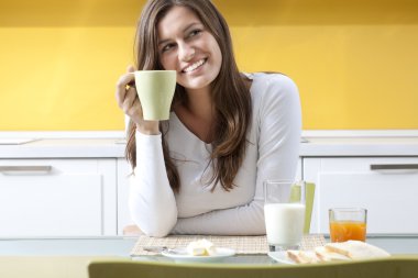 mutlu bir kadın kahvaltı yapıyor