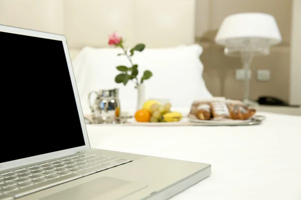 Colazione dell'hotel e computer portatile — Foto Stock