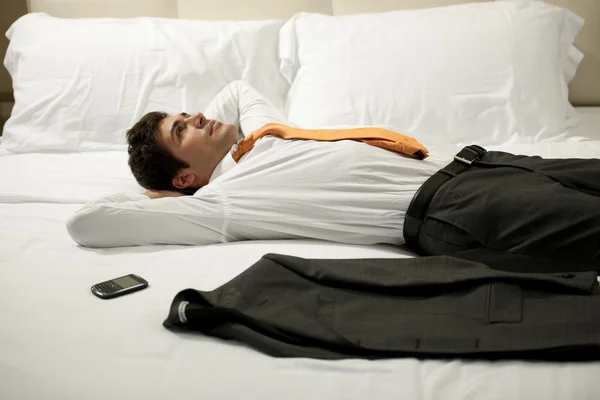 Hombre de negocios cansado acostado en la cama — Foto de Stock