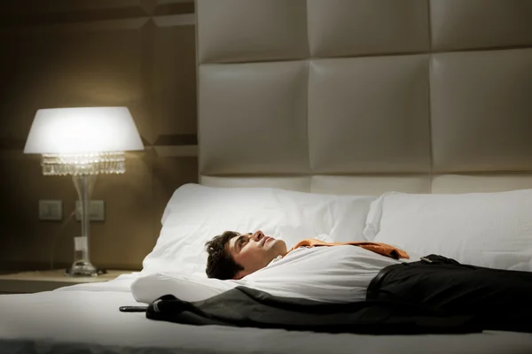 Yatakta yatarken yorgun işadamı — Stok fotoğraf