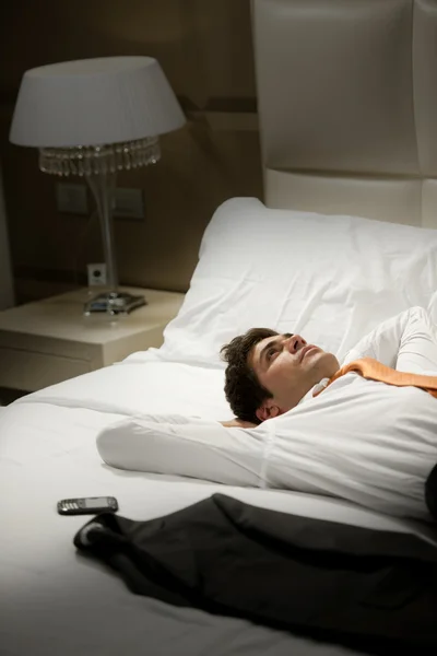 Уставший бизнесмен лежит на кровати — стоковое фото