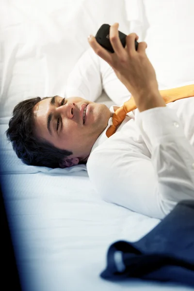 Müder Geschäftsmann liegt im Bett — Stockfoto