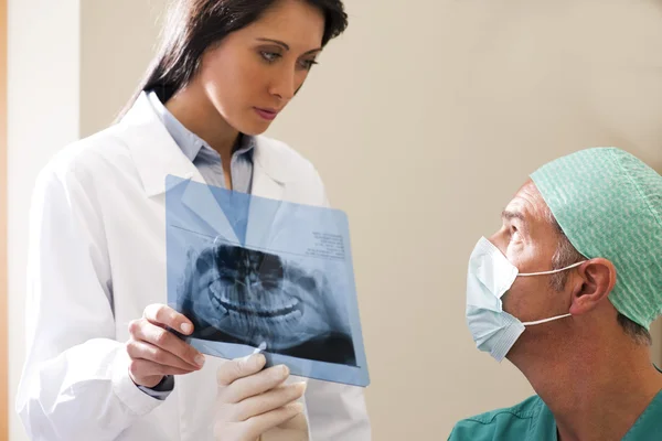 Dos Dentistas Examinando Rayos —  Fotos de Stock
