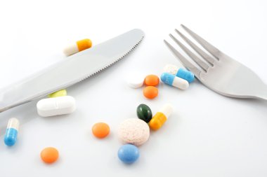 Tablets on plate with fork and knife clipart