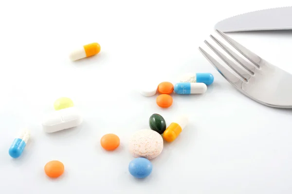 Tabletten auf Teller mit Gabel und Messer — Stockfoto