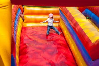 Little girl enjoying the slide clipart